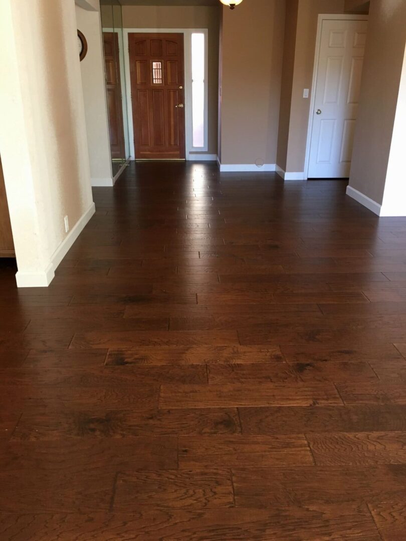 An empty room with brown flooring